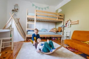 Children playing in cozy bedroom with bunk bed.