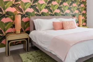 Bedroom with tropical wallpaper and pink accents.