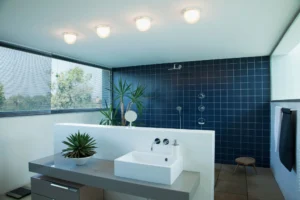 Modern bathroom with blue-tiled shower area.