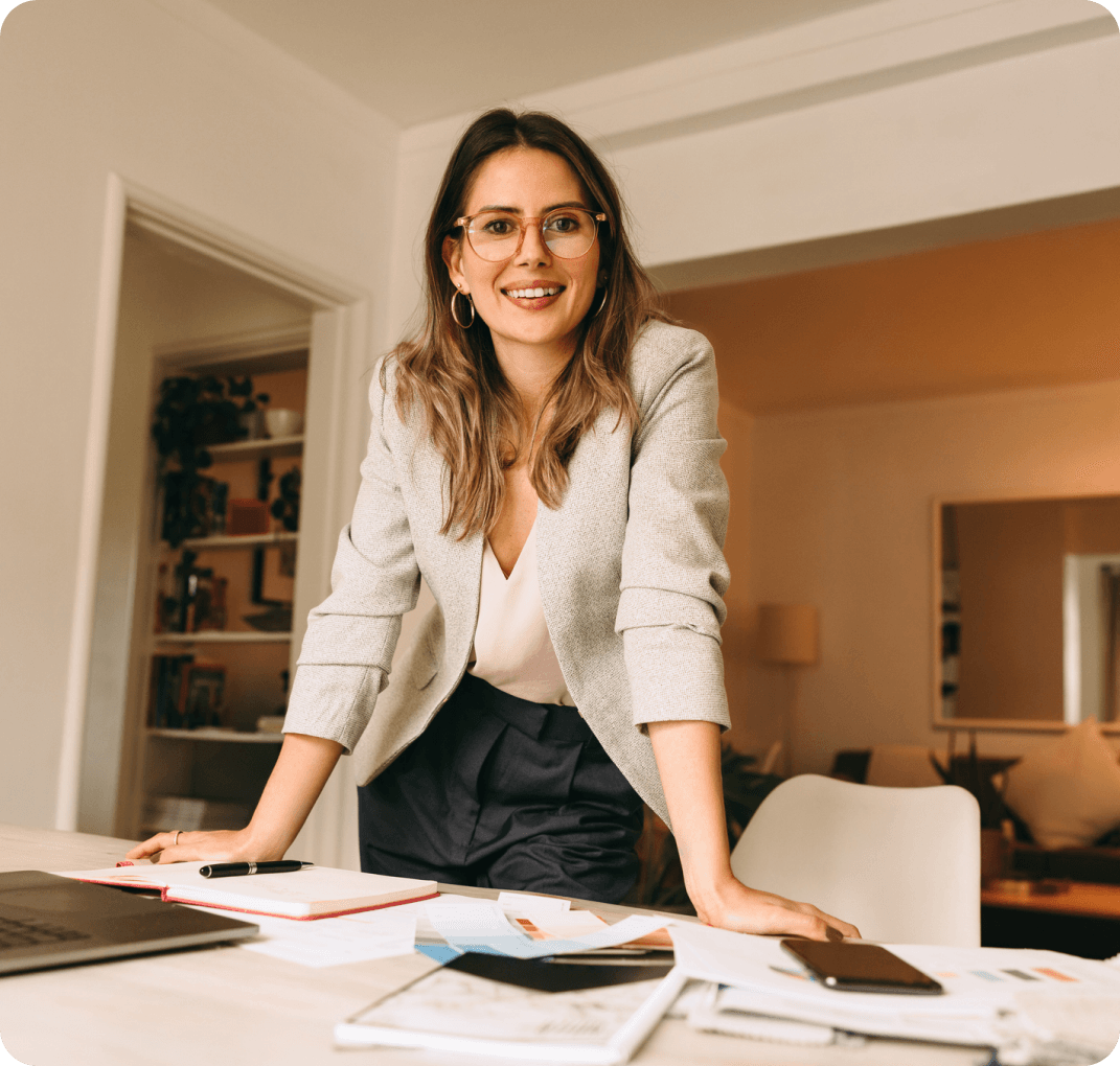 Smiling woman standing at office desk.