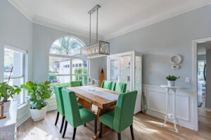 Bright dining room with green chairs.