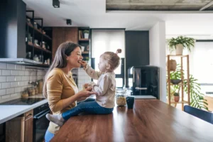 Mother and child eating together in kitchen.
