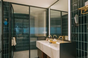 Modern bathroom with black tile walls.